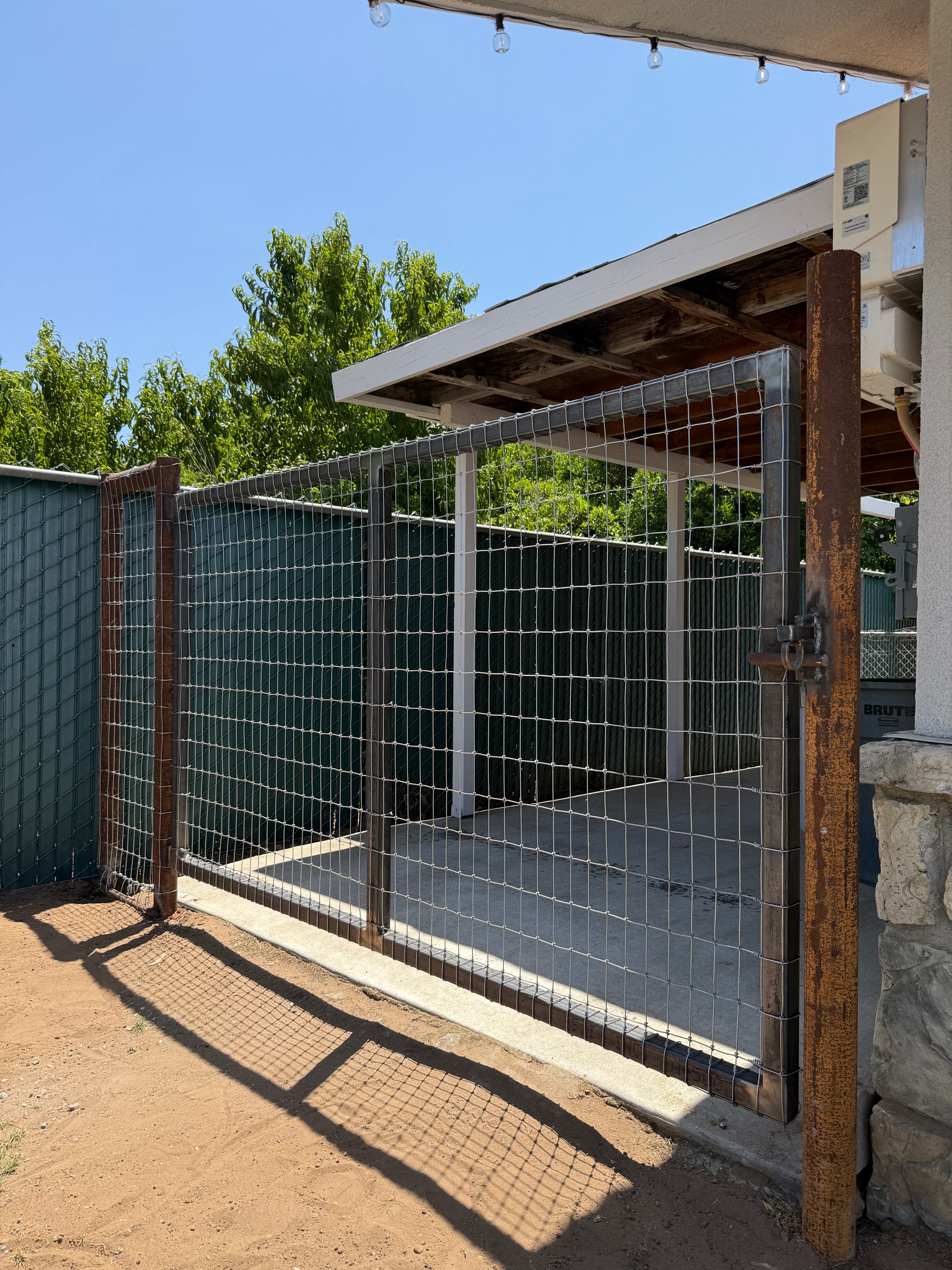 Outdoor gatel with wire mesh and  under a clear blue sky.